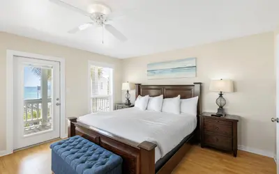 a bedroom with a bed and a blue ottoman at Seashell Castle by Oversee 30A in Santa Rosa Beach