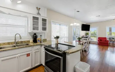 a kitchen with white cabinets and a black stove top oven at Seashell Castle by Oversee 30A in Santa Rosa Beach
