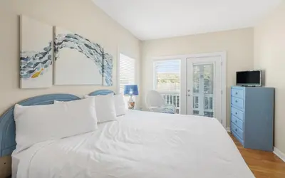 a bedroom with a white bed and a blue dresser at Seashell Castle by Oversee 30A in Santa Rosa Beach