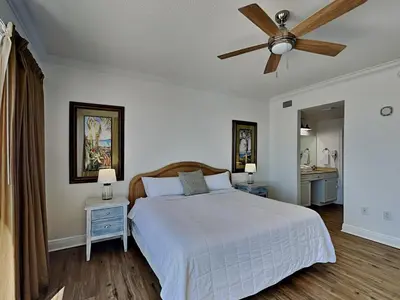 a bedroom with a white bed and a ceiling fan at Boardwalk #1008 in Panama City Beach
