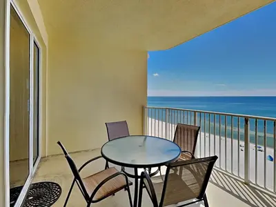 a table and chairs on a balcony with the ocean at Boardwalk #1008 in Panama City Beach