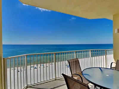 a balcony with a table and chairs and the beach at Boardwalk #1008 in Panama City Beach