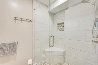 a shower with a glass door in a bathroom at Pool and Beach Trolley Access PCB Resort Condo! in Panama City Beach