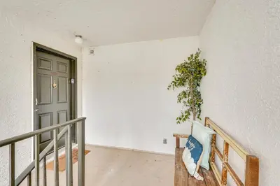 a hallway with a door and a bench with a plant at Pool and Beach Trolley Access PCB Resort Condo! in Panama City Beach