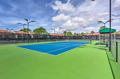 a tennis court with a blue and green court at Pool and Beach Trolley Access PCB Resort Condo! in Panama City Beach