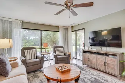 a living room with a couch and a tv at Pool and Beach Trolley Access PCB Resort Condo! in Panama City Beach