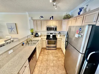 a kitchen with a stainless steel refrigerator and a sink at Tropic Winds 2001 in Panama City Beach