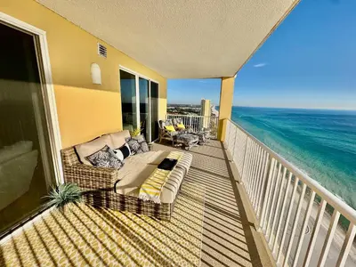 a balcony with a bed and a view of the ocean at Tropic Winds 2001 in Panama City Beach