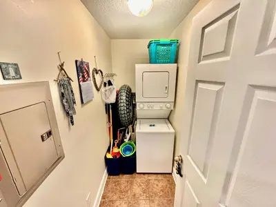 a small room with a door and a refrigerator at Tropic Winds 2001 in Panama City Beach