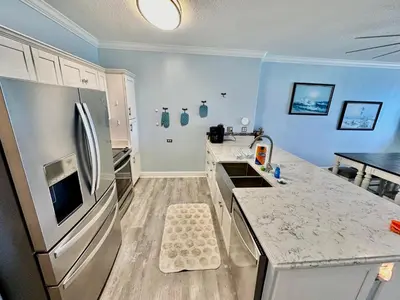 a kitchen with a refrigerator and a counter top at Ocean Reef 804 in Panama City Beach