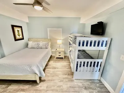 a bedroom with two bunk beds and a flat screen tv at Ocean Reef 804 in Panama City Beach