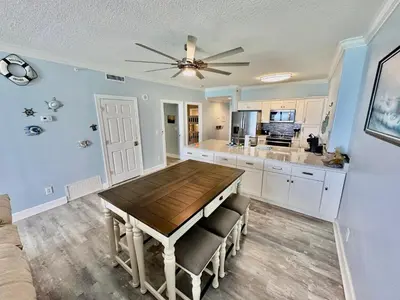 a kitchen with a wooden table and a ceiling fan at Ocean Reef 804 in Panama City Beach