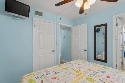 a bedroom with a bed and a ceiling fan at Ocean Front Beach Condo in Panama City Beach