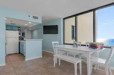 a kitchen with a white table and white chairs at Ocean Front Beach Condo in Panama City Beach