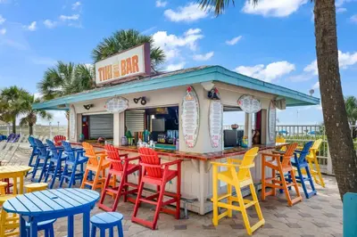 a bar with colorful chairs and tables on the beach at The Summit 828 in Panama City Beach