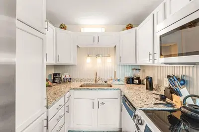 a white kitchen with white cabinets and a sink at The Summit 828 in Panama City Beach