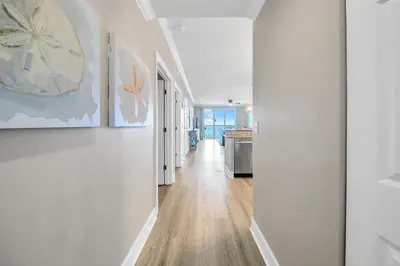 a hallway of a home with white walls and wood floors at Ocean Villa 1803 in Panama City Beach