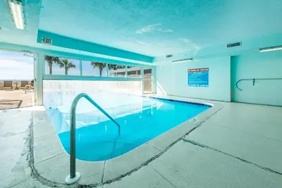 a large swimming pool in a building with a blue water at Ocean Villa 1803 in Panama City Beach