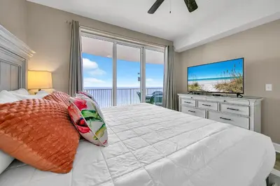 a bedroom with a large bed with a large window at Ocean Villa 1803 in Panama City Beach