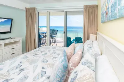 a bedroom with a bed and a view of the ocean at Sugar Shores OR in Panama City Beach