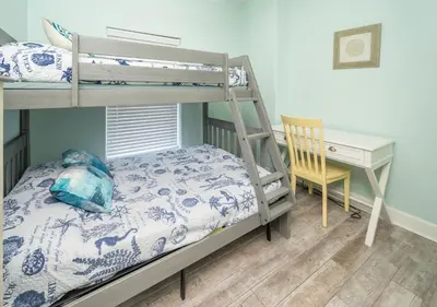 a bedroom with a bunk bed and a desk at Sugar Shores OR in Panama City Beach