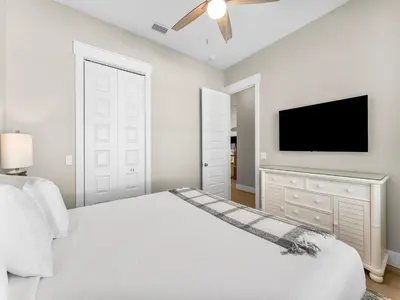 a bedroom with a bed and a flat screen tv at Sugar Sand Sunset in Panama City Beach