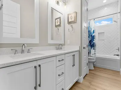 a white bathroom with two sinks and a tub at Sugar Sand Sunset in Panama City Beach