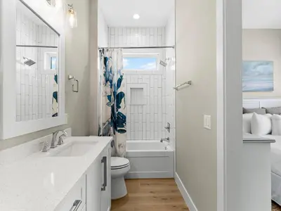 a white bathroom with a toilet and a sink at Sugar Sand Sunset in Panama City Beach