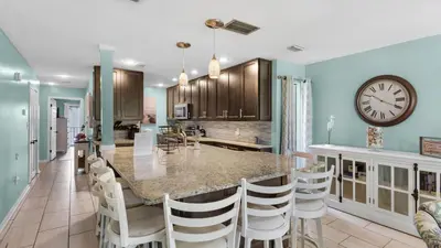 a kitchen with a large island and a clock on the wall at Edgewater Golf Villa 707 in Panama City Beach