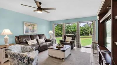 a living room with a couch and a tv at Edgewater Golf Villa 707 in Panama City Beach