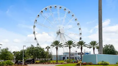 a ferris wheel in a park with palm trees at Edgewater Golf Villa 707 in Panama City Beach