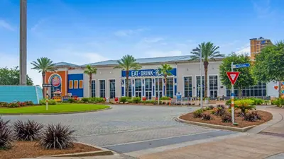 a large building with palm trees in front of a street at Edgewater Golf Villa 707 in Panama City Beach