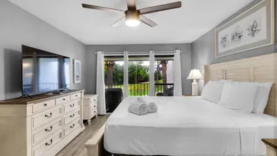 a bedroom with a bed and a flat screen tv at Edgewater Golf Villa 707 in Panama City Beach