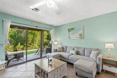 a living room with a couch and a table at Panama City Beach Oasis in Panama City Beach