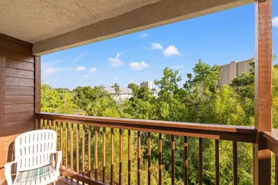 a balcony with a chair and a view of the city at Panama City Beach Oasis in Panama City Beach