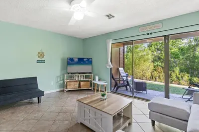 a living room with a couch and a table at Panama City Beach Oasis in Panama City Beach