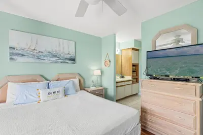 a bedroom with a bed and a large screen tv at Panama City Beach Oasis in Panama City Beach
