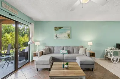 a living room with a couch and a table at Panama City Beach Oasis in Panama City Beach