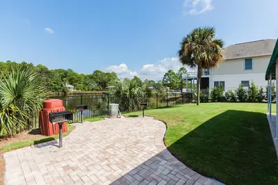 a brick patio with a grill and a yard at St Thomas Square #1204C in Panama City Beach