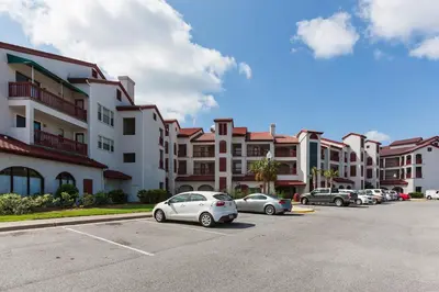 a parking lot with cars parked in front of buildings at St Thomas Square #1204C in Panama City Beach