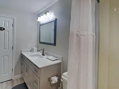 a white bathroom with a sink and a mirror at St Thomas Square #1204C in Panama City Beach