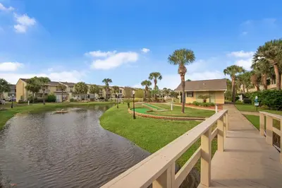 a bridge over a river with houses and palm trees at Gulf Highlands #222 in Panama City Beach