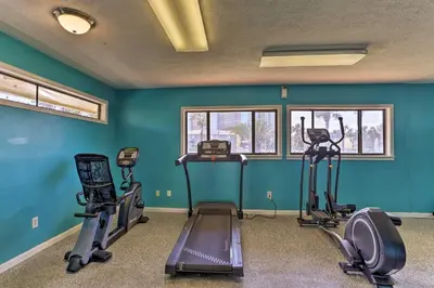 a gym with exercise equipment in a room with blue walls at Resort-Style PCB Townhome Beach Access and Pools! in Panama City Beach