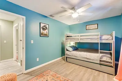 a bedroom with blue walls and bunk beds at Resort-Style PCB Townhome Beach Access and Pools! in Panama City Beach