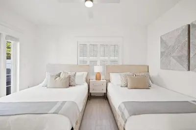 two beds sitting next to each other in a bedroom at 30A Beach Villa Steps to Beach Dog Friendly with Peloton and Bikes in Rosemary Beach