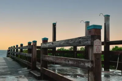 a wooden fence on a pier near the ocean at 30A Beach Villa Steps to Beach Dog Friendly with Peloton and Bikes in Rosemary Beach