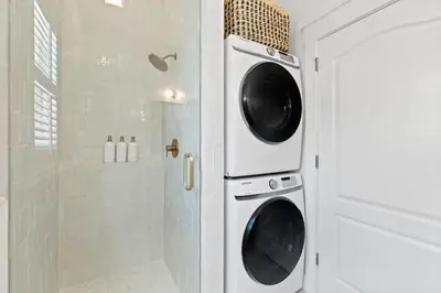 a bathroom with a washing machine and a shower at 30A Beach Villa Steps to Beach Dog Friendly with Peloton and Bikes in Rosemary Beach