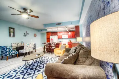 a living room with a couch and a kitchen at Laketown Wharf 1135 NEW in Panama City Beach