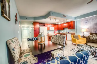 a living room with a table and chairs and a kitchen at Laketown Wharf 1135 NEW in Panama City Beach