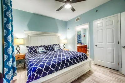 a bedroom with a bed with blue walls and a ceiling at Laketown Wharf 1135 NEW in Panama City Beach
